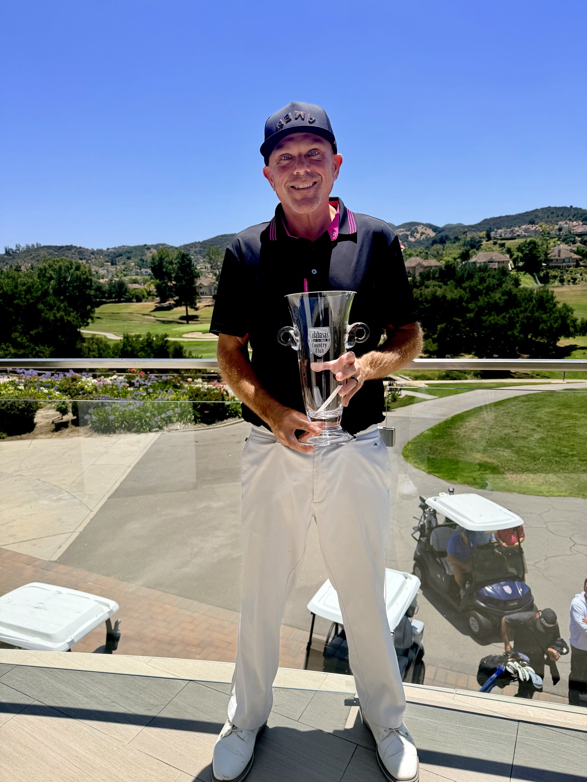 Ryan Byers holding the Calabasas Country Club championship trophy above the course